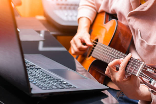 istock man enjoy learning online guitar lesson from internet 1165739827