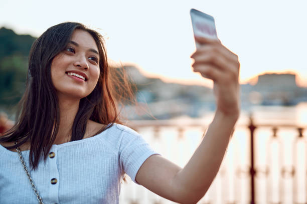 istock Happy asian lady making selfie on bridge 1165739848
