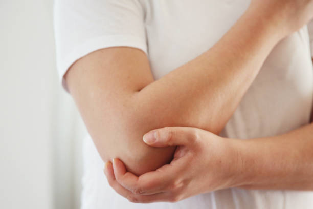 mujer que tiene dolor de codo foto de stock - rubbing human hand human arm women fotografías e imágenes de stock