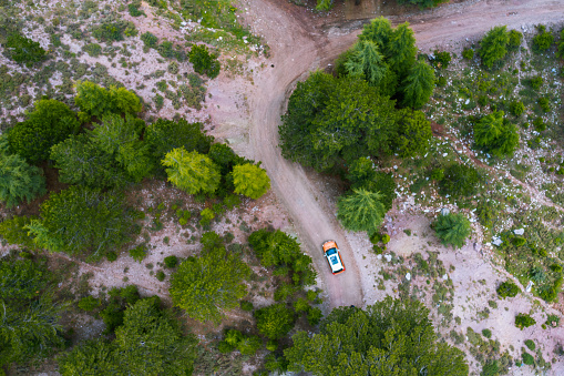 Aerial view of car over mountain road going through tropical rainforest