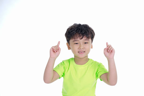 istock Asian little cute boy pointing something, isolated on white background 1165742303