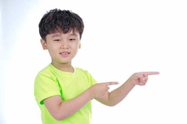 istock Asian little cute boy pointing something, isolated on white background 1165742311