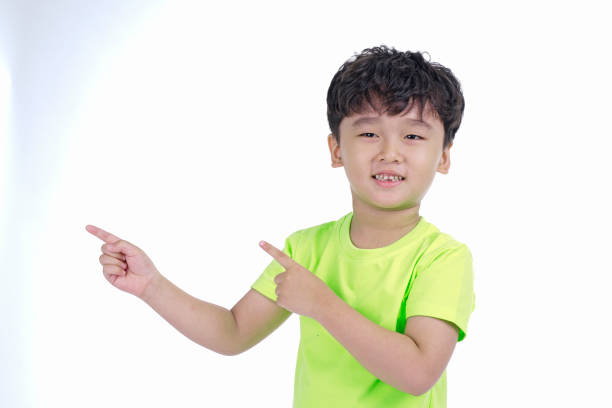 istock Asian little cute boy pointing something, isolated on white background 1165742314