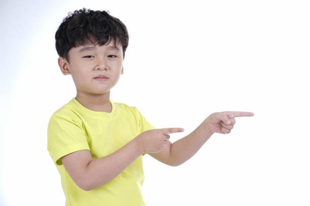 istock Asian little cute boy pointing something, isolated on white background 1165742318