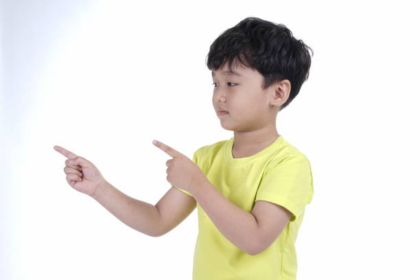istock Asian little cute boy pointing something, isolated on white background 1165742321
