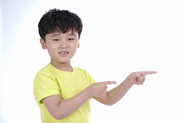 istock Asian little cute boy pointing something, isolated on white background 1165742322