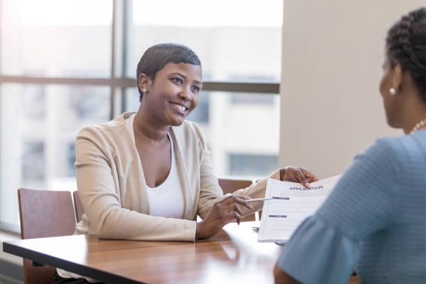 istock Financial counselor and client discuss banking application 1165742853