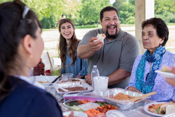 istock Cheerful man enjoys picnic with relatives 1165743028