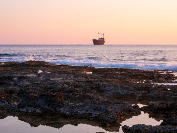 日没時の難破船 - cyprus paphos storm sea ストックフォトと画像