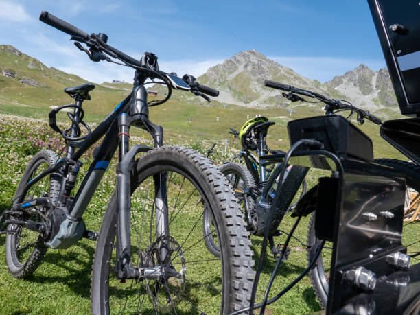 bicicletas de montanha elétricas que estão sendo carregadas em um ponto de carregamento - mountain cycling bicycle tire - fotografias e filmes do acervo