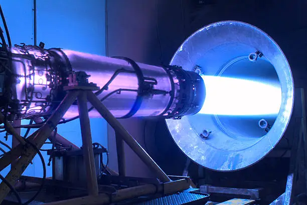 Jet engine with afterburner in a test cell.  Very high thrust creating extreme vibration of engine.  A gas turbine aerospace engine running in a test cell with afterburners on.