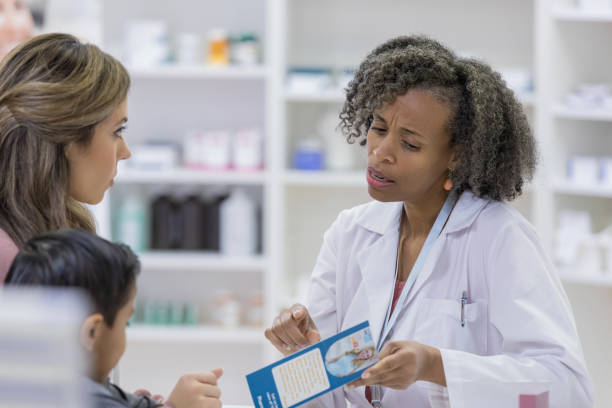 istock Mature adult pharmacist explains medicine side effects using brochure 1165754722
