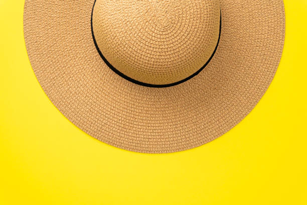 istock Straw hat on pastel yellow  background with copy space for text. Flat lay summer background. Top view 1165754766