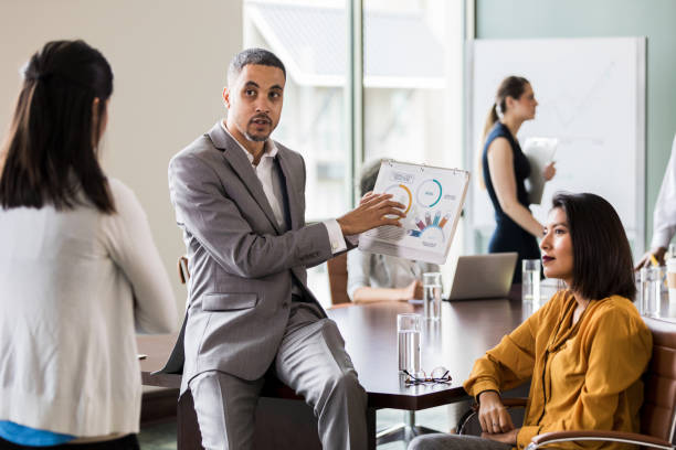 istock Businessman discusses sales graph 1165754919