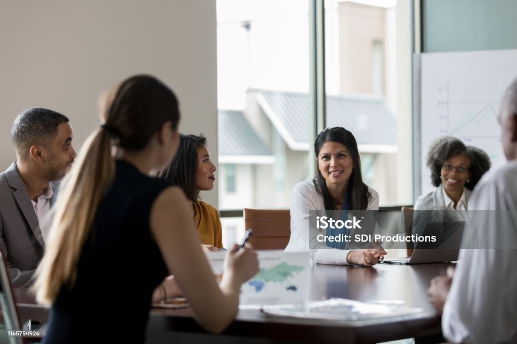 Mid Adult Woman pratar under mötet - Royaltyfri Styrelse Bildbanksbilder