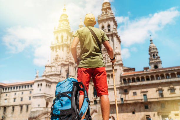 istock Young pilgrim backpacker man standing on the Obradeiro square (plaza) - the main square in Santiago de Compostela as a end of his Camino de Santiago pilgrimage. 1165756185
