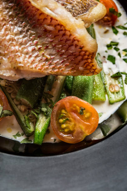 istock Fried fish accompanied by keabos and tomatoes seen from above. Gourmet dish. 1165758586