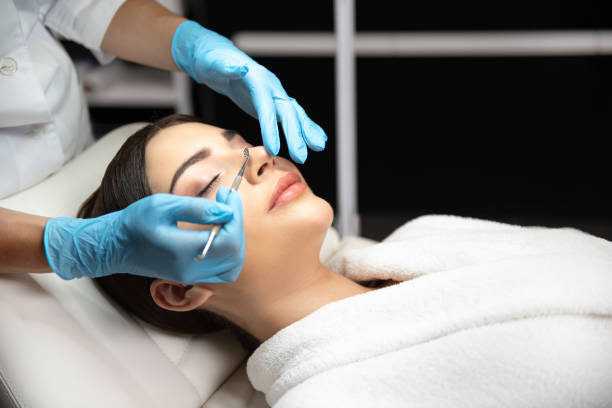 istock Cosmetologist removing impurities from lady face with blackhead remover 1165760029