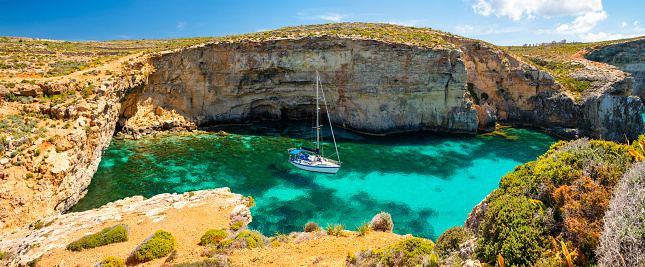 Malta. Summer tropical landscape with picturesque bay. Blue lagoon with yacht. Comino island. Attraction of Malta. Summer nature background.