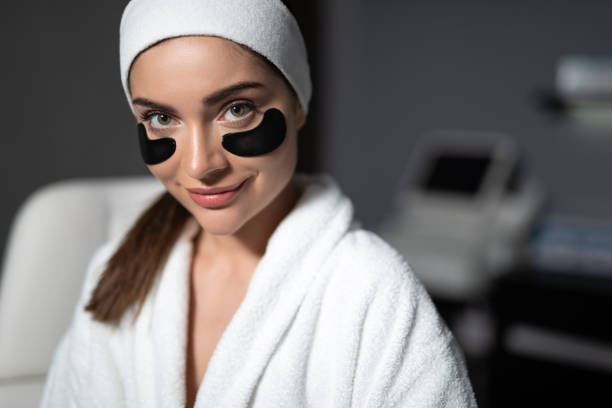 istock Beautiful young woman using black under-eye patches 1165760767