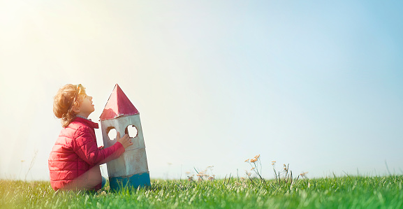 Little Boy With Toy Space Rocket on the Meadow