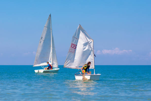Child sailing. Kid learning to sail on sea yacht. Healthy water sport for school kids. Yachting class for young sailor. Children on boat. Family summer vacation on tropical island. Beach activity.