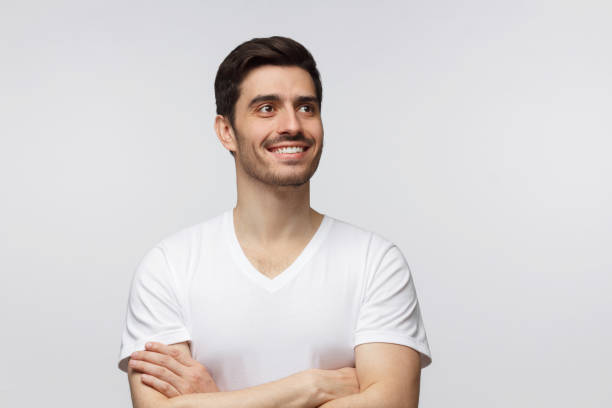istock Dreaming young man looking away while standing isolated on gray background 1165763925