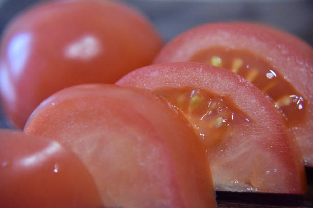 red slices of tomato on wooden deck