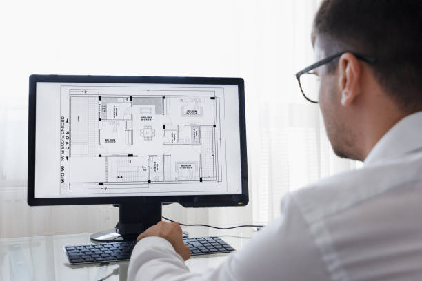 LOS ANGELES, CALIFORNIA - JUNE 3, 2019: Engineer, Constructor, Designer, Architect in Glasses Working on a Personal Computer. He Working With Building Blueprint on a Desktop. Freelance Work. An illustrative editorial image. los angeles, california - 3 de junio de 2019: ingeniero, constructor, diseñador, arquitecto en gafas trabajando en un ordenador personal. trabajó con building blueprint en un escritorio. trabajo independiente. una imagen editorial ilustrativa