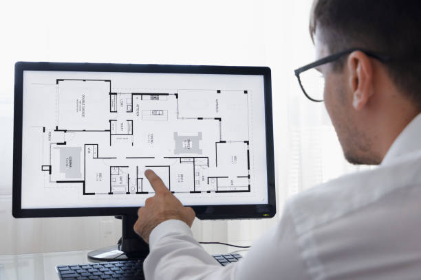 istock LOS ANGELES, CALIFORNIA - JUNE 3, 2019: Engineer, Constructor, Designer, Architect in Glasses Working on a Personal Computer. He Working With Building Blueprint on a Desktop. Freelance Work. An illustrative editorial image 1165770327