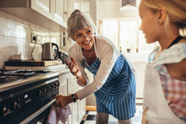 nonna e bambino che cucinano in cucina - grandmother senior adult family domestic kitchen foto e immagini stock