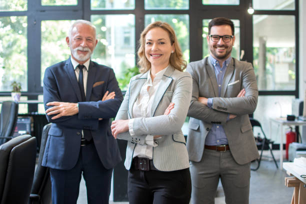 istock Three business people standing with their arms crossed in office 1165775581
