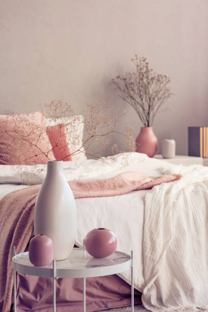 istock Different types of vases on small coffee table in bright bedroom interior 1165776117