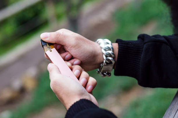 Close-up of person hand holding electronic cigarette stock photo