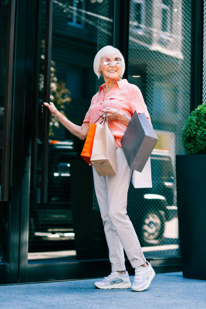 istock Smiling cheerful pensioner walking into the shop 1165780763