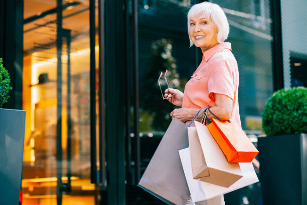 istock Smiling elderly lady with colorful shopping bags 1165780862