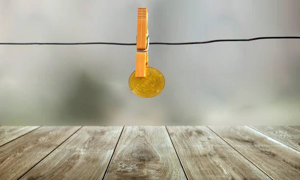 o bitcoin dourado está pendurando com o clothespin alaranjado na linha do metal com fundo do bokeh, conceito dos feriados - algerian currency - fotografias e filmes do acervo