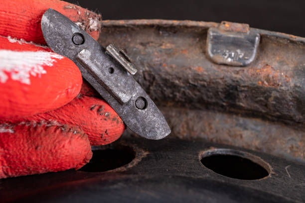 istock Lead weights on the rim. Accessories for the vulcanizer in the workshop. Dark background. 1165780974