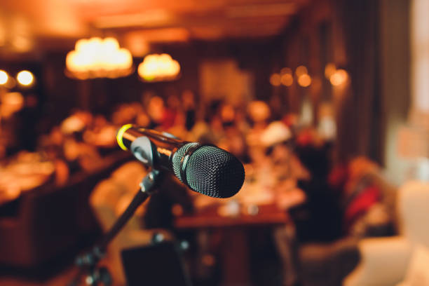istock Microphone on stage against a background of auditorium. 1165790238