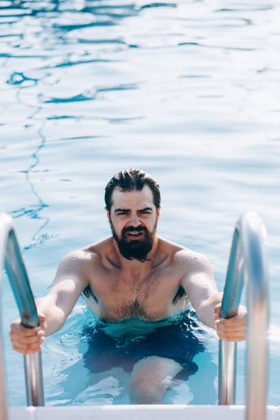istock Millennial man  at the outdoor pool 1165791706