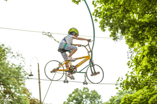 szczęśliwa uczennica korzystających z aktywności w parku przygód wspinaczki w letni dzień - education high up sport sports helmet zdjęcia i obrazy z banku zdjęć