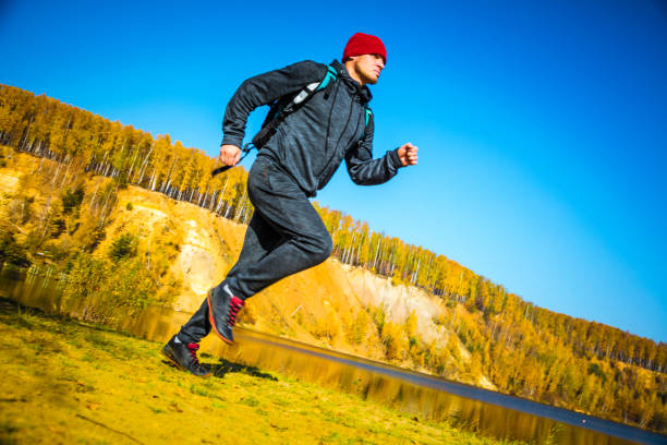 istock Running around the autumn lake and forest - low angle view 1165800308