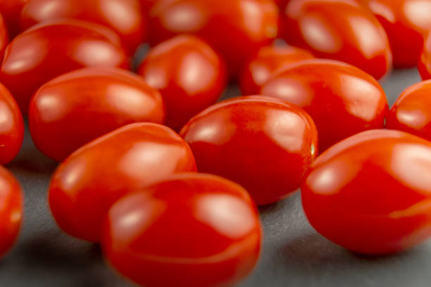 Fresh cherry tomatoes on grey stone background. stock photo