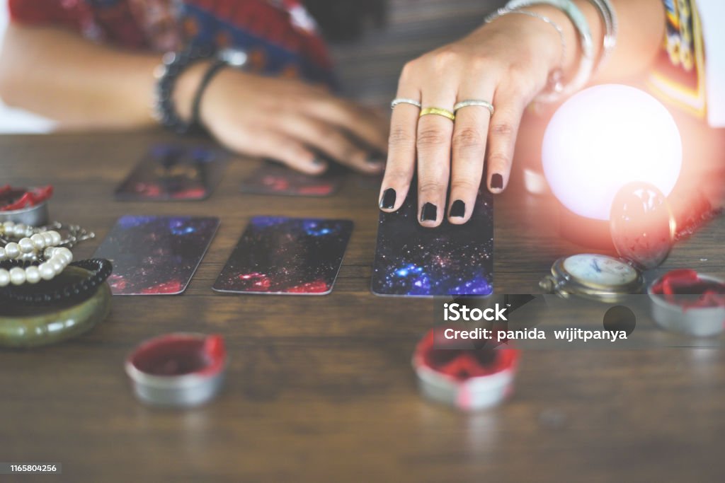 Tarot cards reading divination Psychic readings and clairvoyance concept - Crystal ball fortune teller hands Tarot cards reading divination Psychic readings and clairvoyance concept / Crystal ball fortune teller hands Fortune Teller Stock Photo
