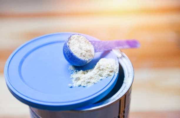 poudre de lait dans la cuillère sur la boîte pour le bébé et la table en bois - formula photos et images de collection