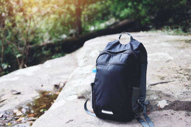 istock Backpack on nature with bottle for backpacker hiker on the rock in the forest on mountain 1165804413