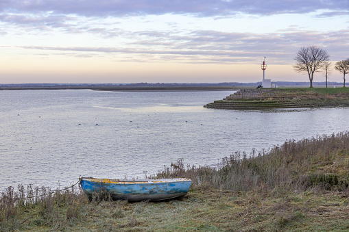 Landscape at Saint-Valery-Sur-Somme with the river Somme, an old boat on its margin at sunset