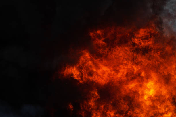 pericolose forti fiamme rosse di fuoco industriale e drammatiche nuvole nere di fumo coperto di cielo. dispersione atmosferica - heat dispersion foto e immagini stock