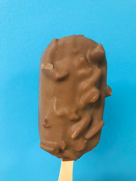 istock Chocolate nuts and fudge ice cream bar against a bright blue background 1165819911
