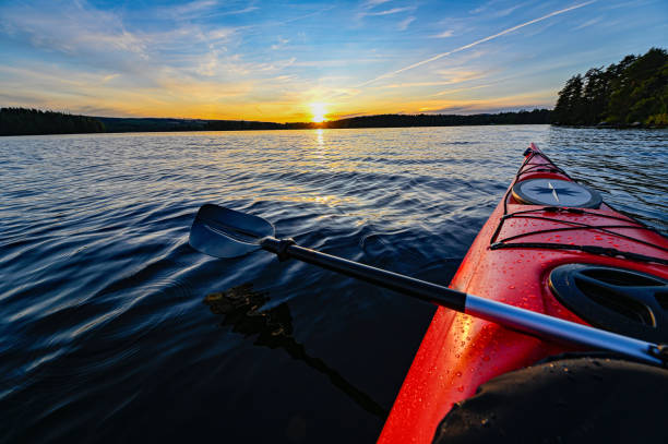 istock red plastic kayak on calm water in the sunset 1165838668